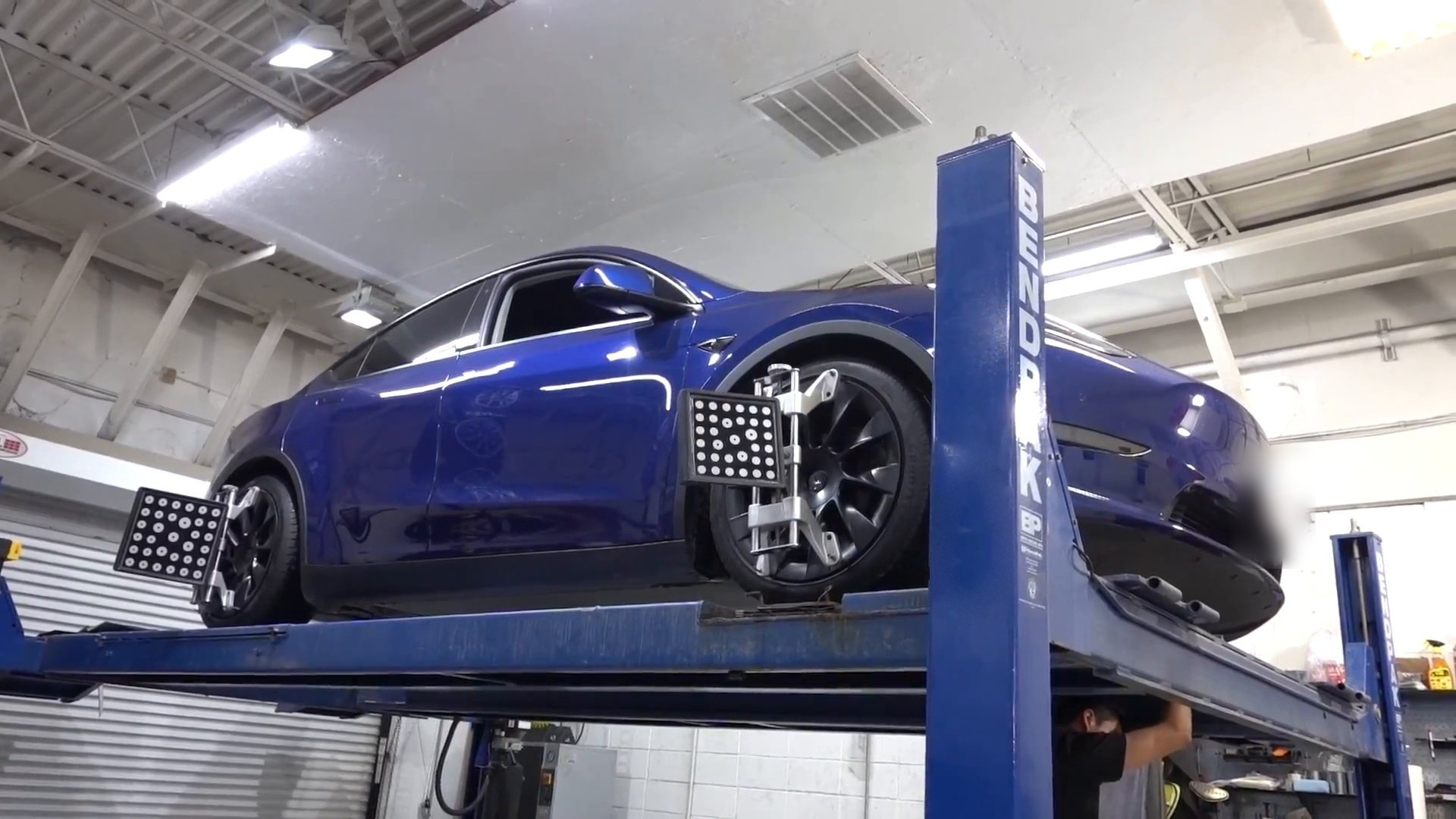 Tesla Model Y on the alignment rack at EVS Motors with alignment targets on its wheels