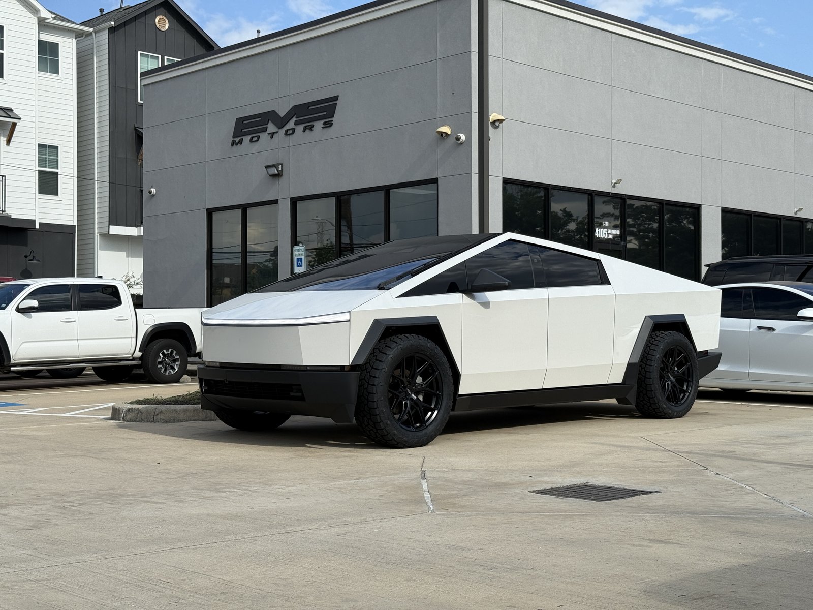 Satin white wrapped Cybertruck with black flares and wheels at EVS