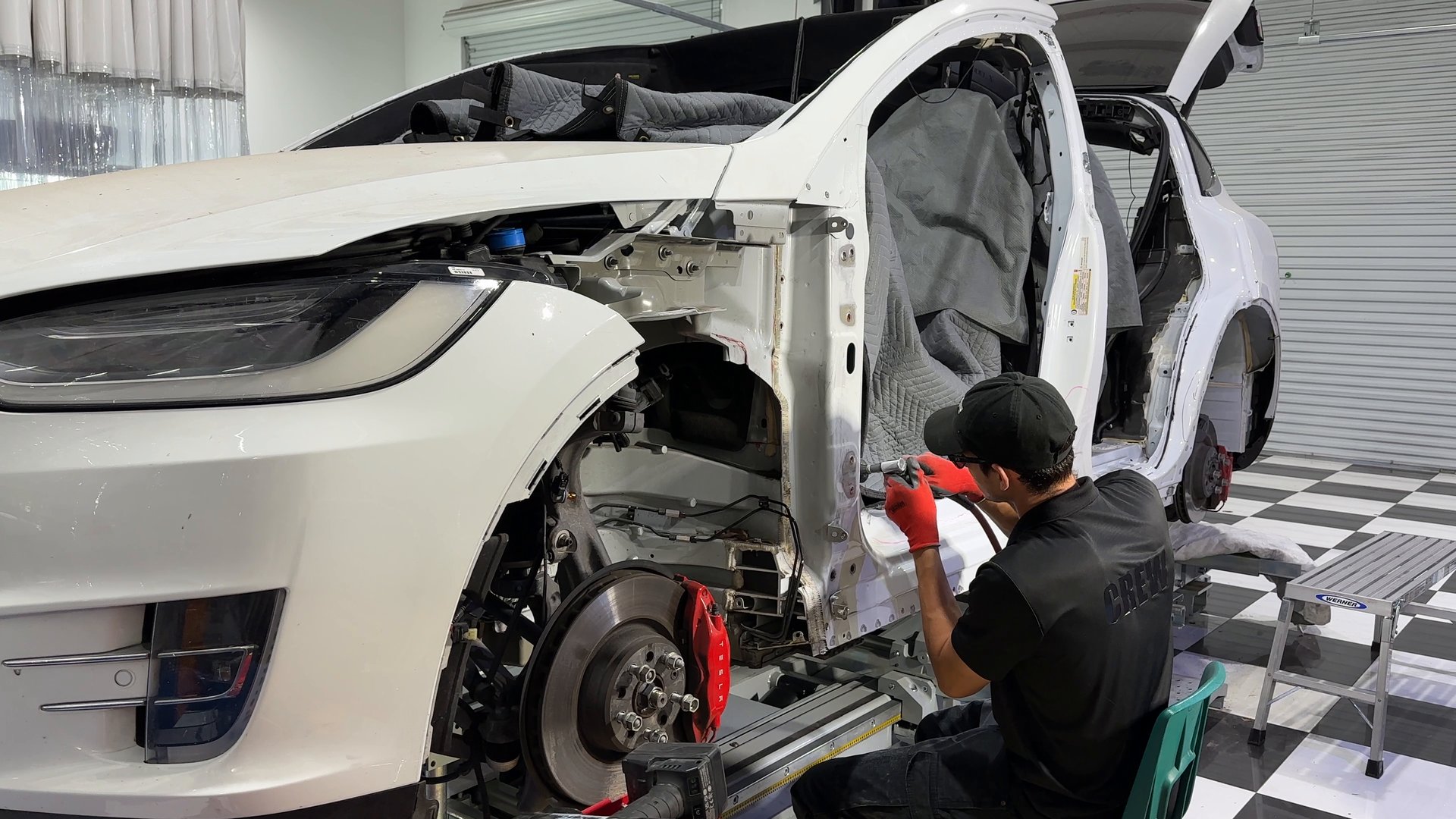 EVS Motors technician welding during a structural repair on a Tesla Model X
