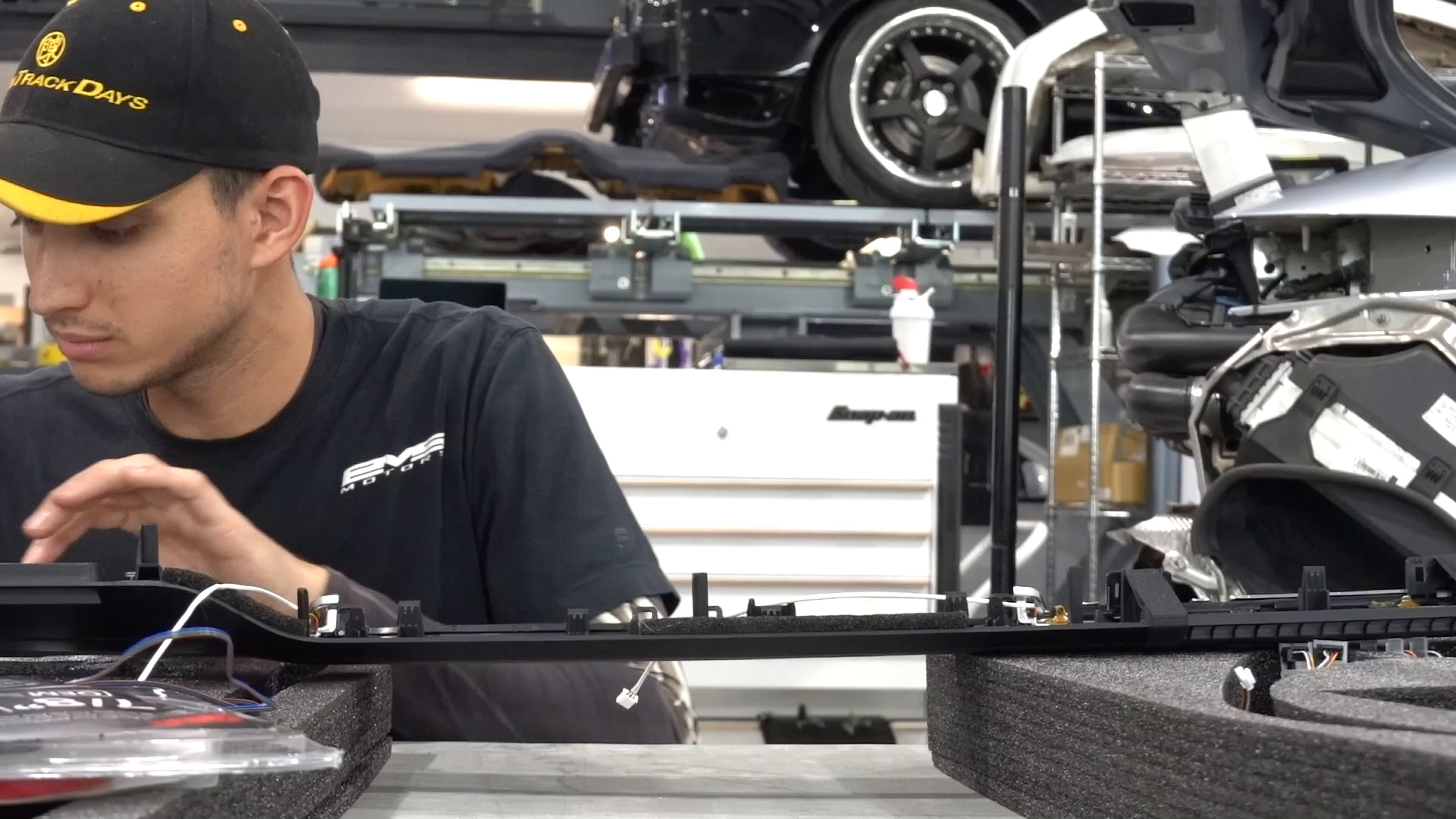 EVS Motors technician wiring an interior trim panel on the bench