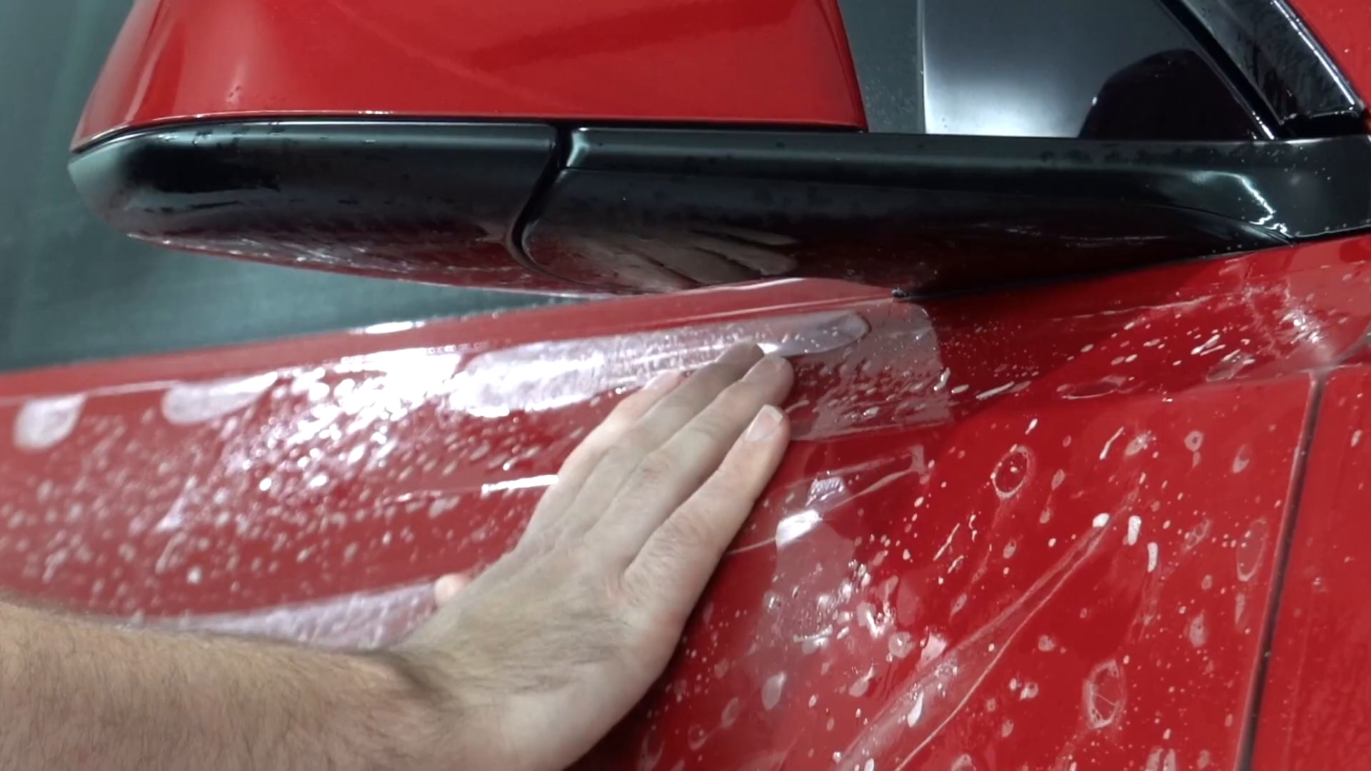 Installer applying paint protection film to a Tesla Model Y